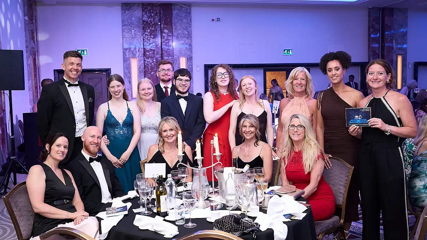 MYTIME Young Carers team celebrating their Charity Awards 2025 win at the Royal Lancaster Hotel, pictured at the ceremony dinner table with their trophy.